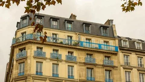 Haussmann building facade in Paris featuring blue balconies and autumn leav.. Stock Photos
