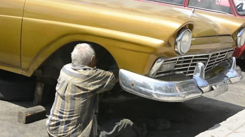 Hava Cuba a typical scene of a man repairing his old classic US 1950's auto to Stock-Footage 65359135