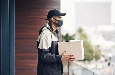 Have I got the wrong address. a masked young man delivering a package to a place Stock Photos