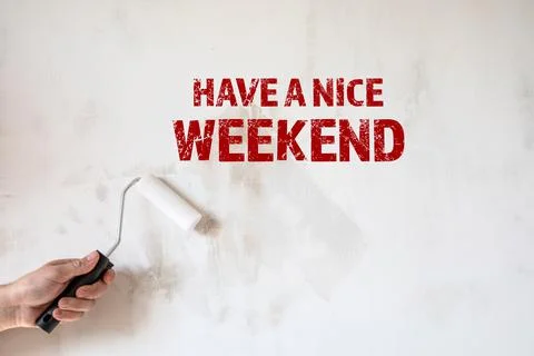 Have a nice Weekend. Paint roller in a man's hand. Concrete wall background Stock Photos
