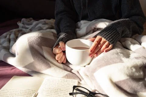 Having coffee and reading in bed on lazy sunny morning.  Stock Photos