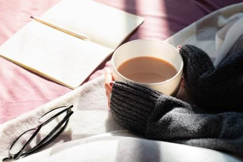 Having coffee and reading in bed on lazy sunny morning.  Stock Photos