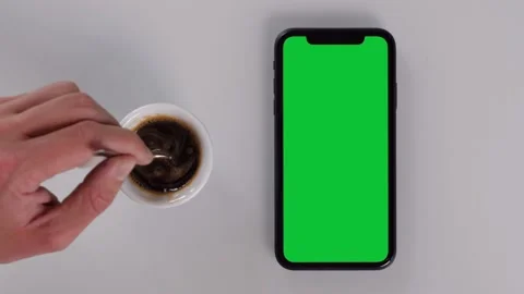 Having a Coffee while Watching a Smartphone with Green Screen Stock Footage 142596062