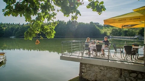 Having drinks and lunch on beautiful restaurant terrace along lake side Stock Footage 121591356
