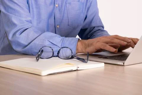Having eye glasses on the open notebook next to computer on the wooden table Foto stock