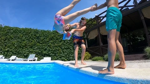 Having fun children jumping and diving into swimming pool Stock Footage 120435231