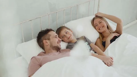 Having fun enjoying weekend sunny morning in bed, carefree adorable small child Stock Footage 140892571