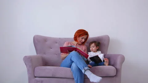 Having fun with her cute little daughter on the couch at home, 库存影片 131786476