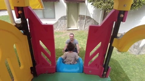Having fun in the park. The father is waiting for his child sliding down. Video stock 219556593