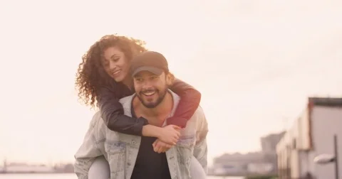 Having fun while young man carries young woman on his back Stock Footage 84956205