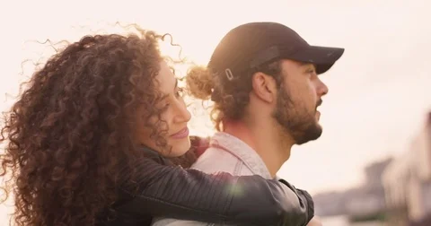 Having fun while young man carries young woman on his back at the sunset Stock Footage 84956262