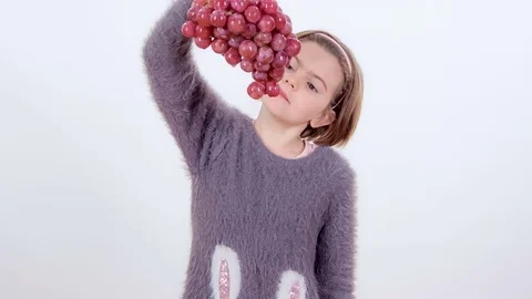 Having grapes in her hand and eating it from the bottom Stock Footage 83724387
