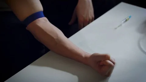 Having Injection. Man Working Right Hand on the Desk. Bandage on His Upper Arm. Stock Footage 71172626