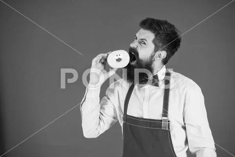 Having snacks. Diet and healthy food. Baker eat doughnut. Chef man in cafe Stock Photos