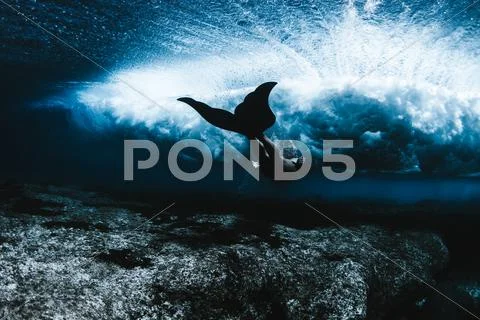 Hawaii, Female wearing diving flippers swimming under waves Stock Photos