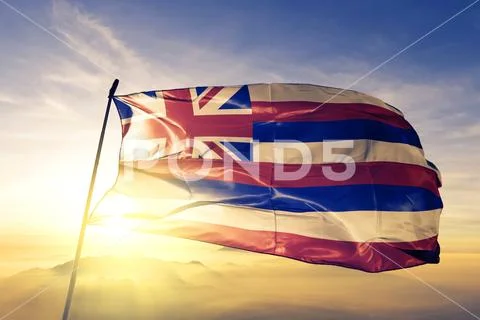 Hawaii state of United States flag waving on the top sunrise mist fog Stock Photos