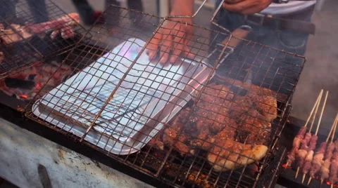 A hawker broiling mutton chops over a charcoal Stock Footage 40616066