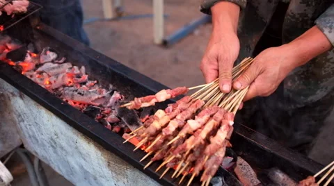 A hawker broiling mutton cubes on bamboo picks Stock Footage 40616077