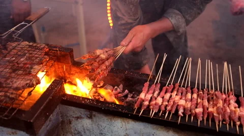 Hawker broiling mutton cubes over a charcoal flame Stock Footage 40616056