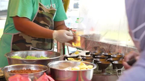 Hawker can seen preparing Putu Piring during Ramadan bazaar, Malaysia. Видео 238573701