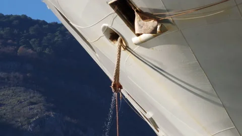 Hawser rope being pulled up into a docked ship through cat hole on the bow. Stock Footage 231192216
