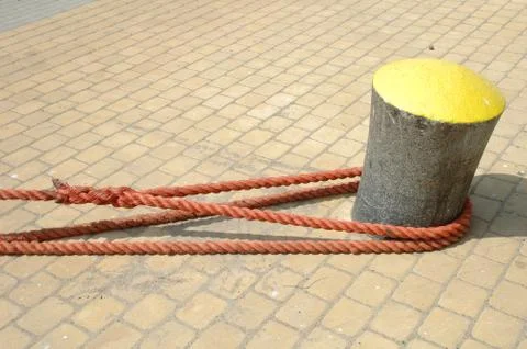 Hawsers attached  to the bollard in harbour Stock Photos