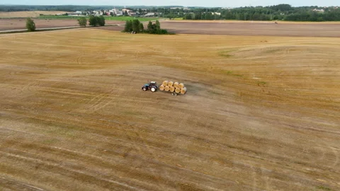 Hay Making. Tractor transportation the round bales on Hay Trailer. 動画素材 212451945