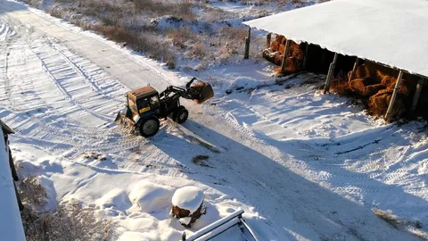 Hay tractor stacking hay bales in hangar. Winter of Russia. Aerial shot. Stock Footage 130148698