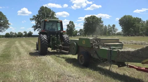 Haying square bales with a tractor and trailer. Stock Footage 61398024