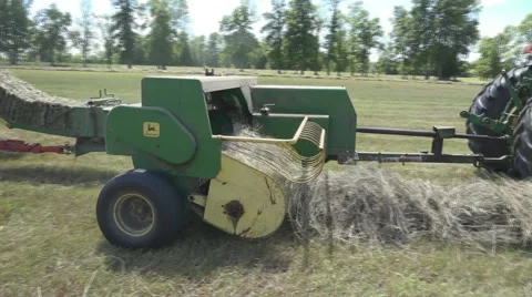 Haying square bales with a tractor and trailer. Stock Footage 61399266