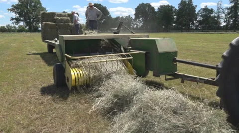 Haying square bales with a tractor and trailer. Stock Footage 61542552