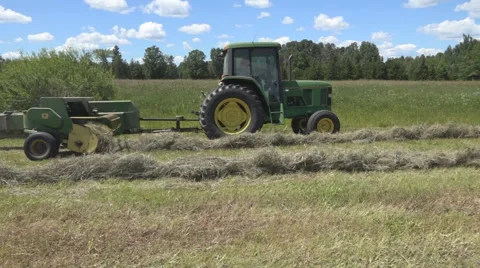 Haying square bales with a tractor and trailer. Stock Footage 61546306