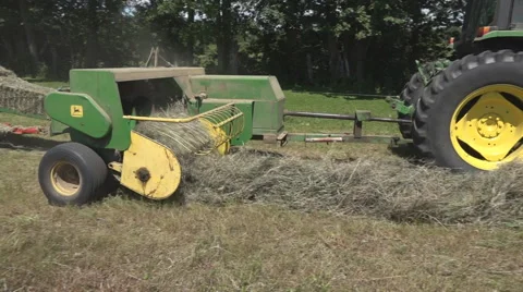 Haying square bales with a tractor and trailer. Stock Footage 61547477