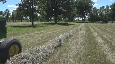 Haying square bales with a tractor and trailer. Stock Footage 61547746
