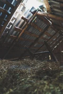The hayloft in the barn. Sunlight breaks through the leaky roof. Village vibe Stock Photos