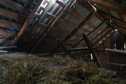 The hayloft in the barn. Sunlight breaks through the leaky roof. Village vibe Stock Photos