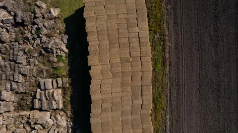 Haymaking. Flying over the large open warehouse of straw bales on an industri Stock Photos