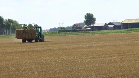 Haymaking process using a John Deere agricultural tractor and a New Holland.. Stock Footage 339907761