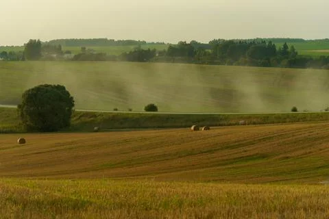 A haystack in a field against the background of beautiful clouds after the ra Stock Photos