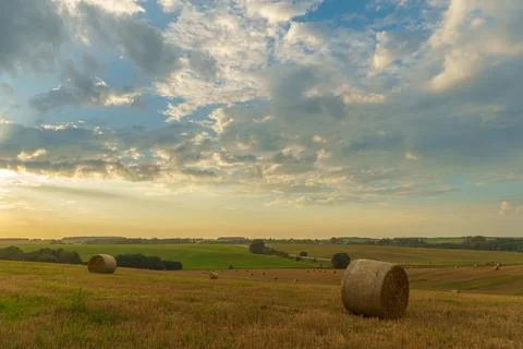 A haystack in a field against the background of beautiful clouds after the ra Stock Photos