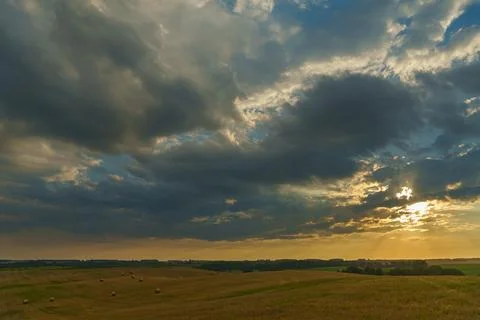 A haystack in a field against the background of beautiful clouds after the ra Stock Photos