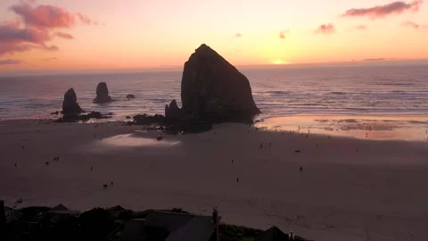 Haystack Rock and fluffy, cotton candy skies at sunset at Cannon Beach, Oregon, Stock Footage 273758218