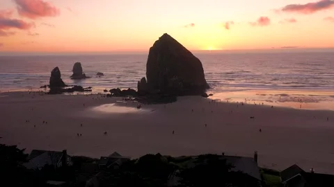Haystack Rock and people walking next to it and enjoying a colorful peaceful Stock-Footage 273758217