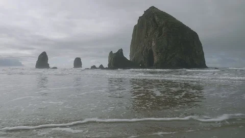 Haystack rock sandy Cannon Beach Oregon Pacific Northwest on cloudy overcast day Vidéo 122804421