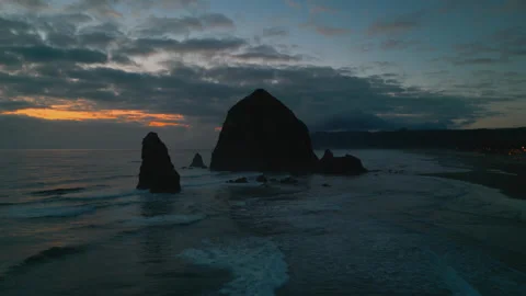 Haystack Rock sea stack at Cannon Beach during twilight hour with reflections Stock Footage 335965277