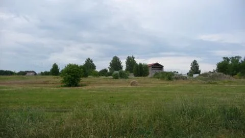 A haystack on a Russian meadow, a flock of birds in the distance. Stock Photos