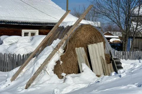 Haystack under the snow in the village Stock Photos