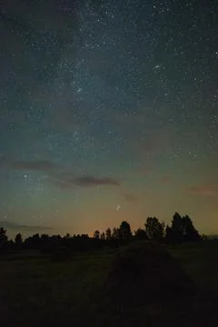 Haystack under the starry sky in a field on a summer night in Russia Stock Photos