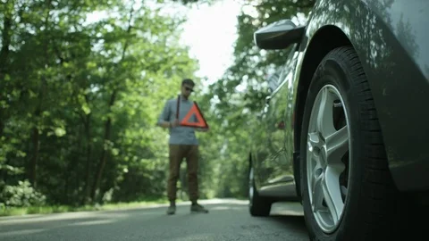 Hazard Light On. Young Man Holding a Warning Triangle Stock Footage 79736351