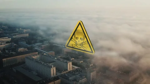Hazard Warning Sign Floating Above a City Covered in Dense Morning Smog Fog 库存影片 331045758